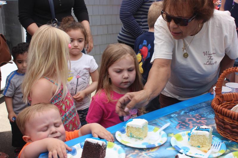 Winna Dean serves cake to Holley Chouinard while Chris Chouinard struggles to sneak a piece for himself. BY MATTHEW BERNAT